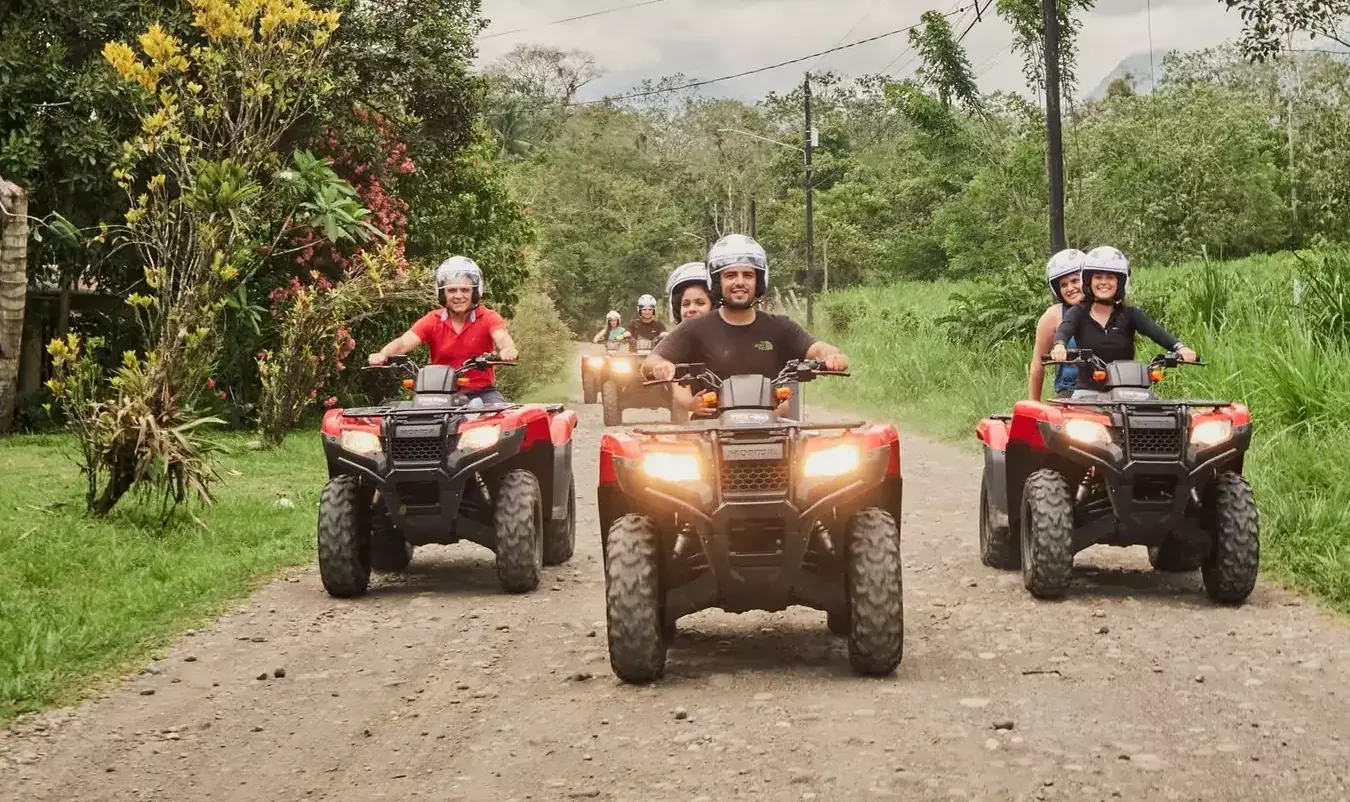 Grupo de cuatriciclos recorriendo un sendero de bosque tropical