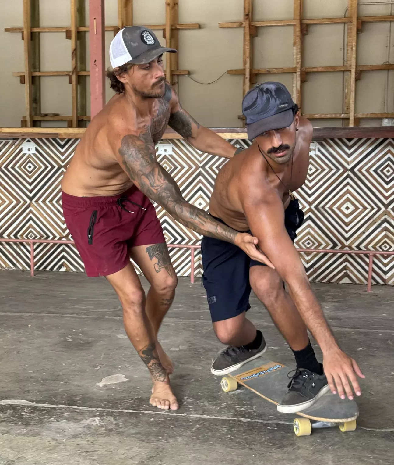 Dos instructores practicando surfskate sobre una tabla